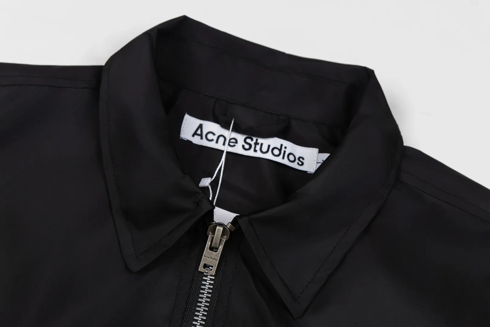 140 Acne Studios Lapel Coach Jacket Glossy nylon back lettering loose windproof jacket Classic lapel coach jacket version, STOCKHOLM back logo, Nordic simple style High-density glossy nylon fabric, light and crisp, windproof and water-repellent, with high-end gloss Metal main zipper + side eyelet details, cuff hem elastic cuffs, lock-type windproof Simple no large print on the front chest, letters on the back as a visual highlight, suitable for street commuting Style number: ST 014# Color: Off-white Black Burgundy Size: S-XL